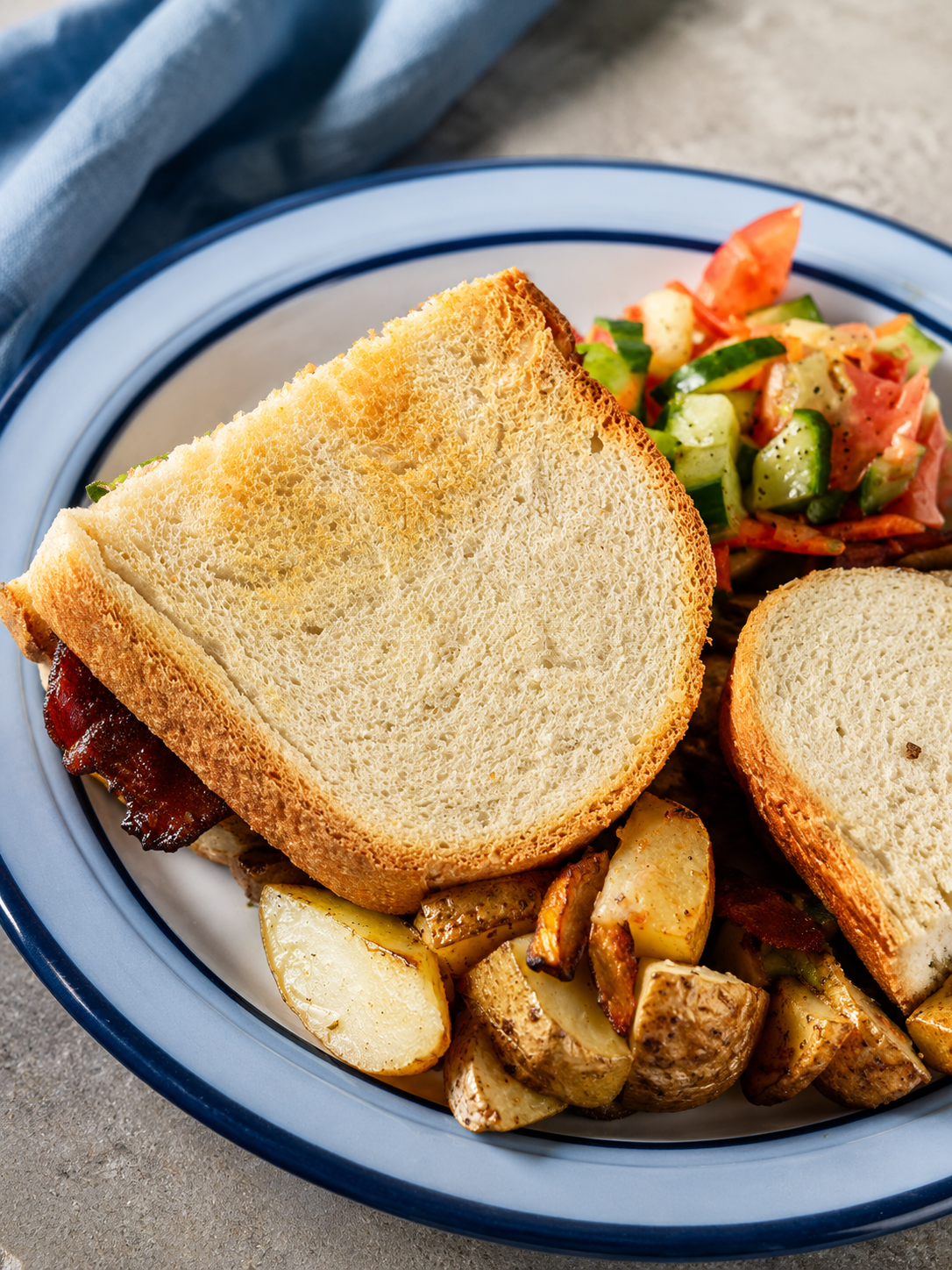A toasted sandwich with bacon, roasted potatoes and salad at Annie's Place Cafe